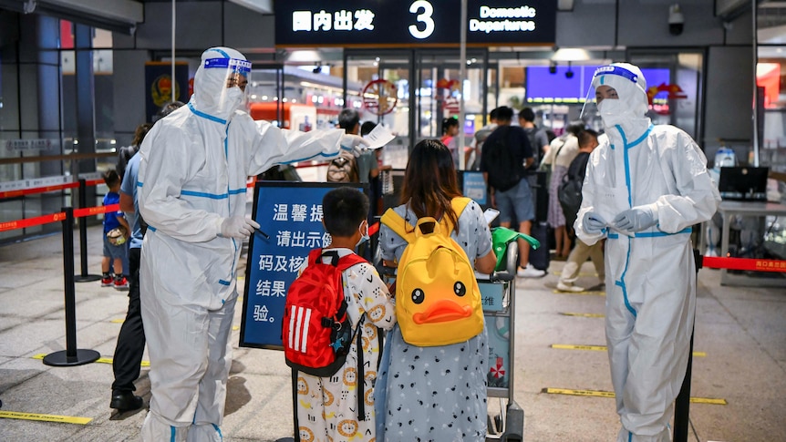 Tourists pass through an airport gate in Haikou in Hainan Province, China.