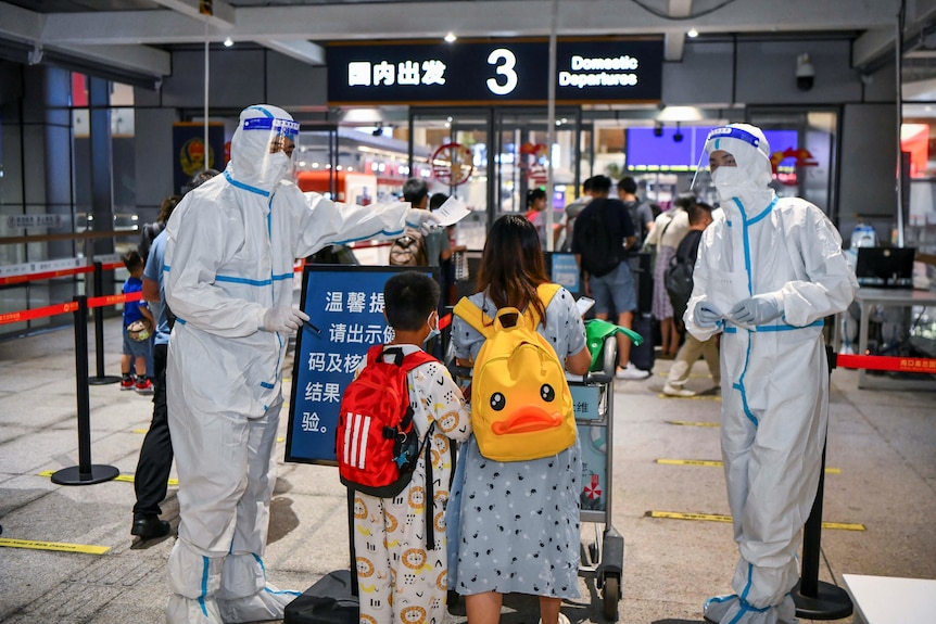 Tourists pass through an airport gate in Haikou in Hainan Province, China.