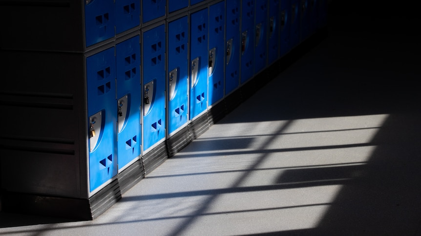 A row of blue lockers in a school corridor