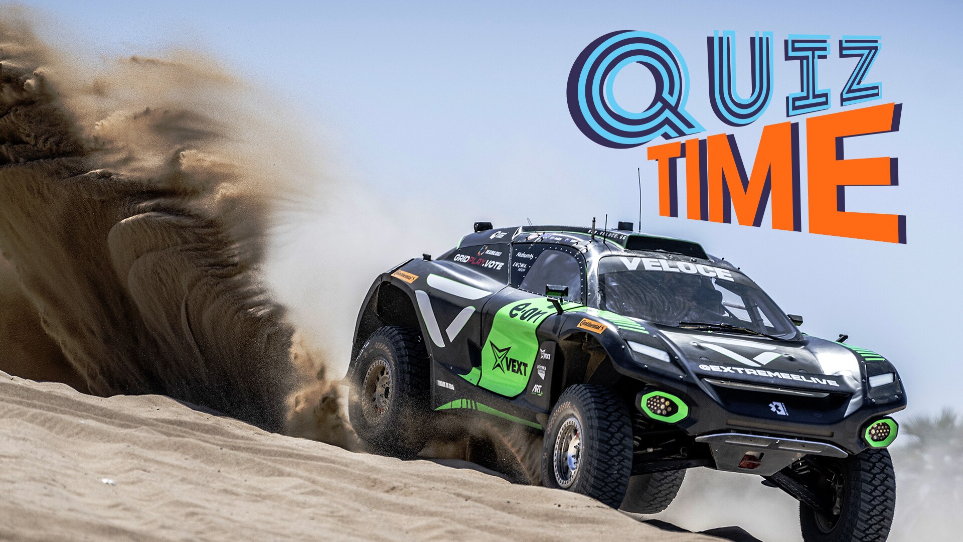 An electric SUV speeds through the desert spraying sand behind as it turns.