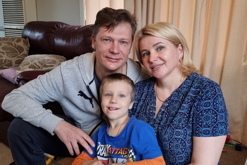 Father, mother and their young son sitting in a lounge room.