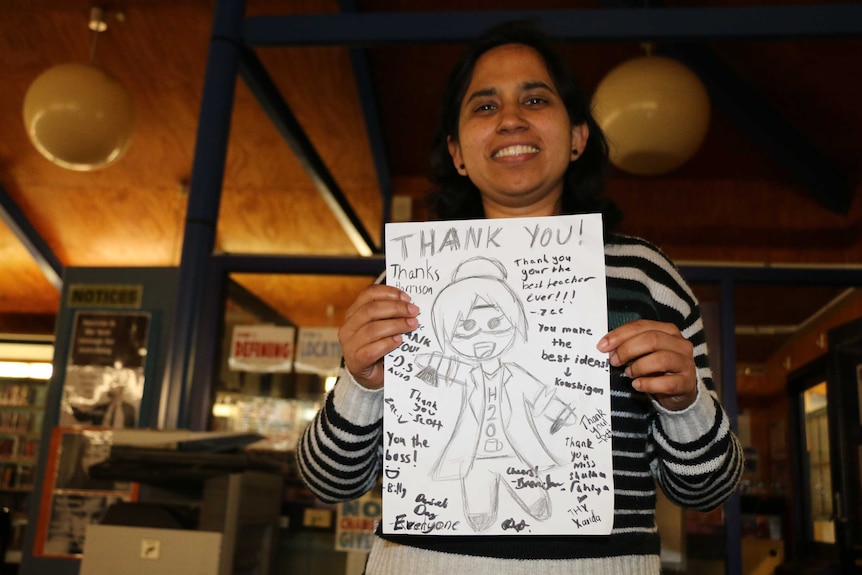 Keerti Shukla holds a hand drawn thank-you card from a student.