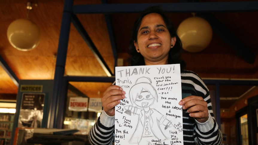 Keerti Shukla holds a hand drawn thank-you card from a student.