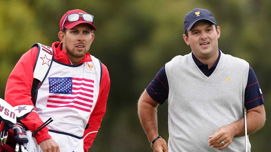 US golfer Patrick Reed and his caddy, Kessler Karain, look at the course during the Presidents Cup.