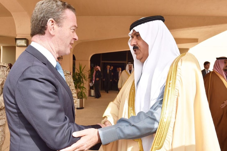 Christopher Pyne shakes the prince's hand, men in traditional Saudi headdress in the background.