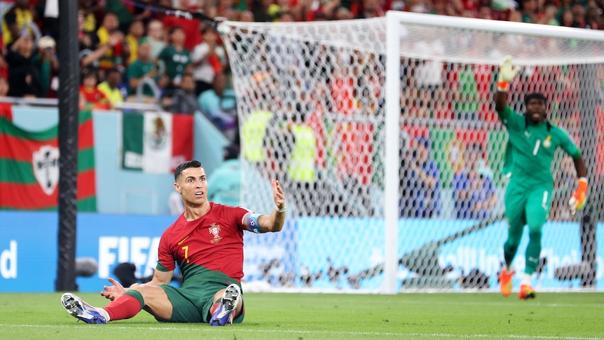 Portugal's Cristiano Ronaldo sits on the ground after going down in the box during a Qatar World Cup match against Ghana.