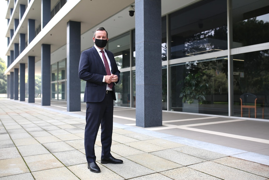 Mark McGowan standing outside WA Parliament wearing a black COVID mask.