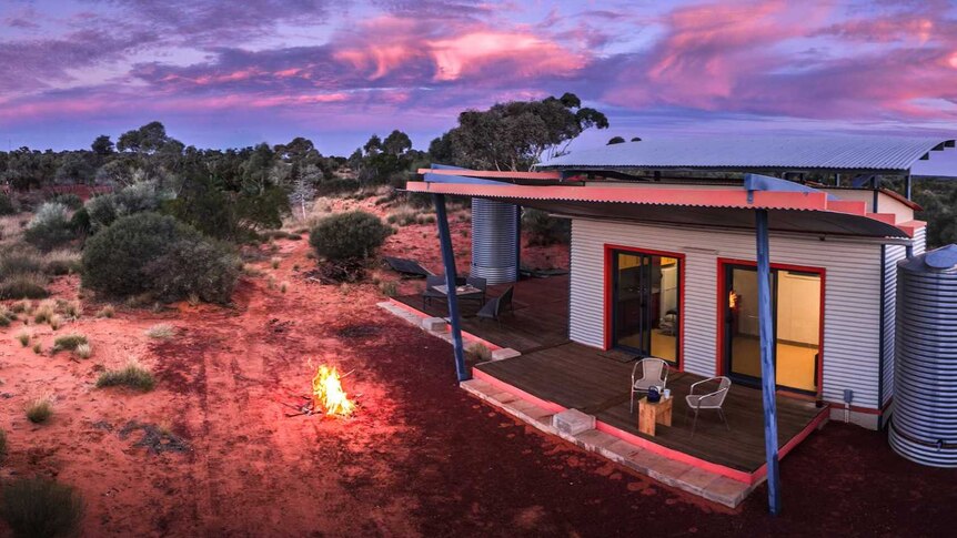 An accommodation facility in bushland, at sunset.