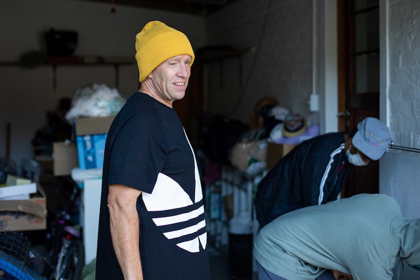 Man in yellow beanie standing in garage