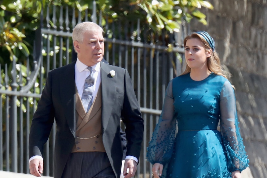 A man in a three piece suit with tails walks with his daughter in a teal formal dress with mesh sleeves
