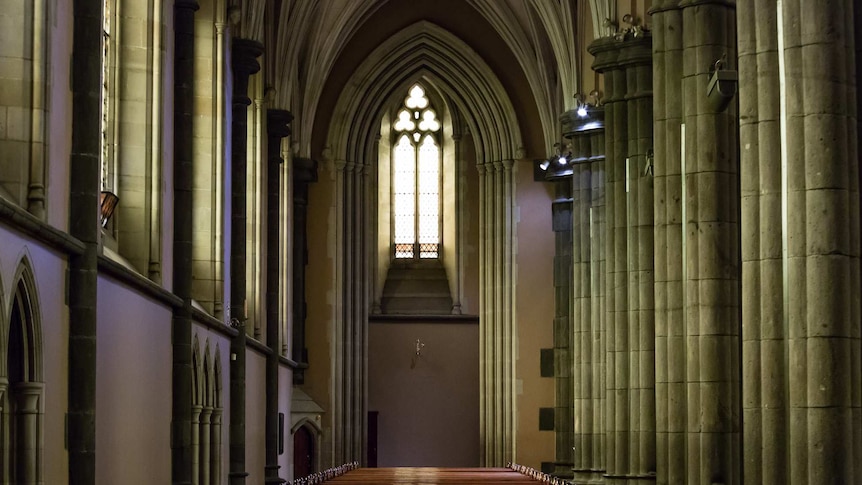 A row of pews under an arch window inside St Patrick's Cathedral.