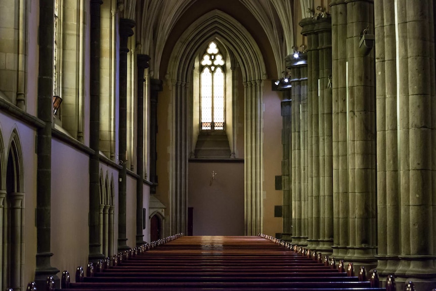 A row of pews under an arch window inside St Patrick's Cathedral.