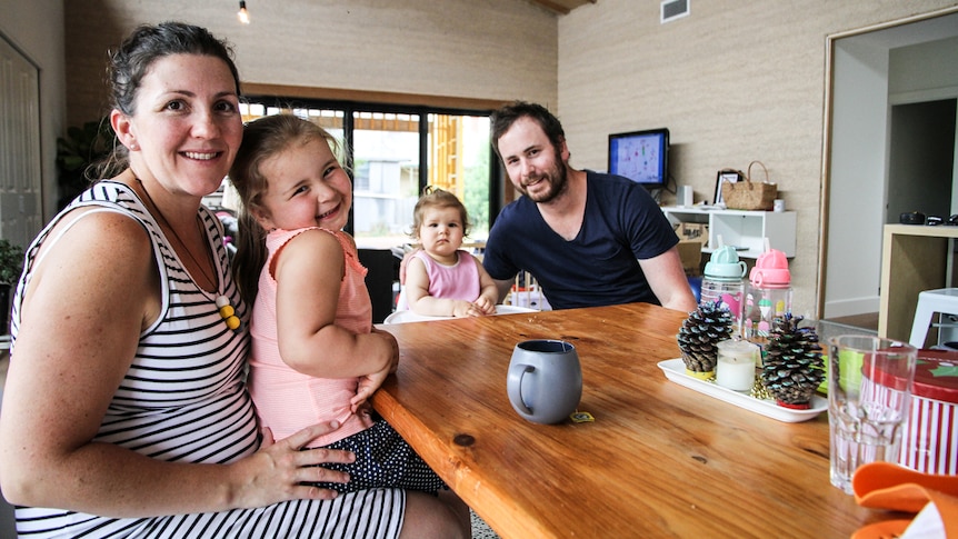 Sandie and Joshua Richmond from Birchip sitting at the dining table with their two children Sienna (left) and Ari (right).
