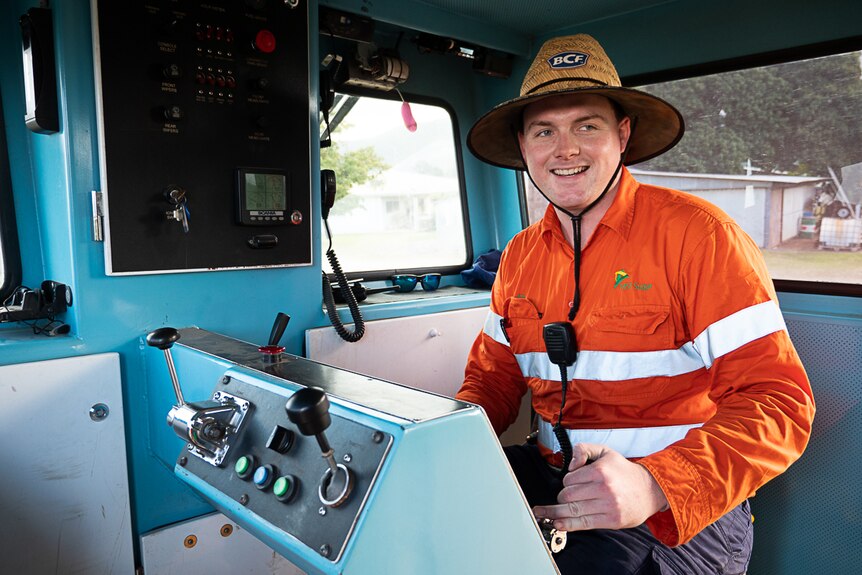 Young man in high vis at controls of train