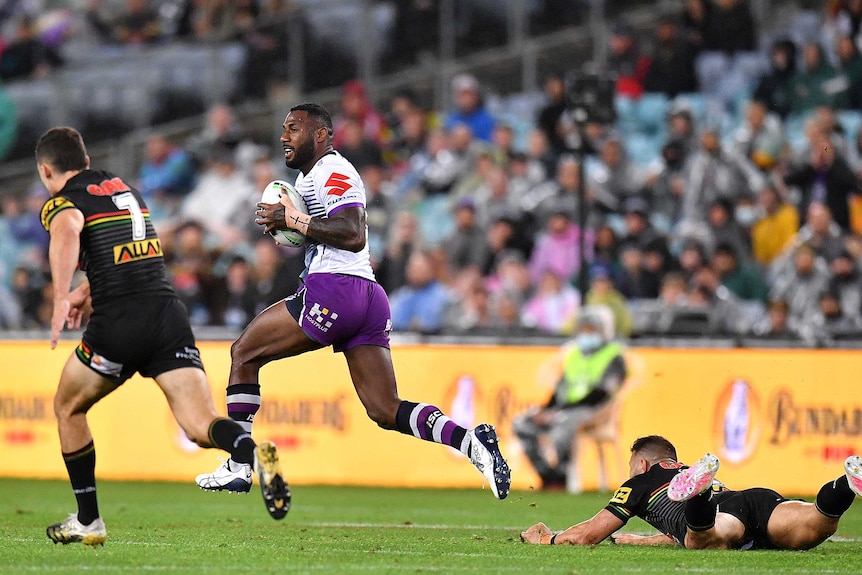 Melbourne Storm's Suliasi Vunivali breaks away from the Penrith Panthers in the NRL grand final.