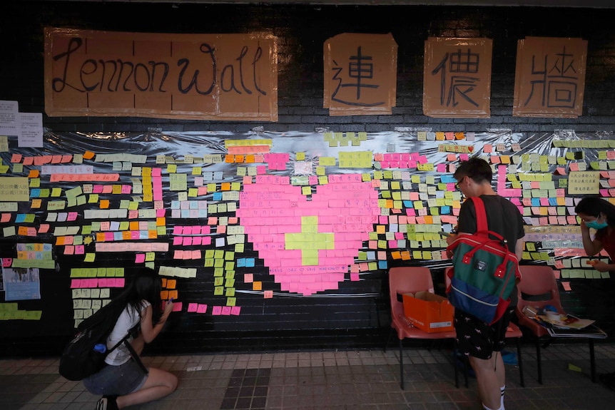 Supporters visit a colourful Lennon Wall full of protest messages.