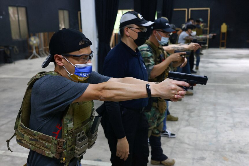 Trainees practice target shooting with their airsoft guns during an airsoft gun shooting lesson.