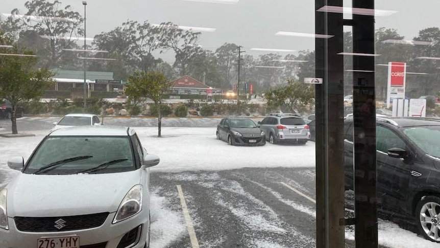 A supermarket car park covered in hail.