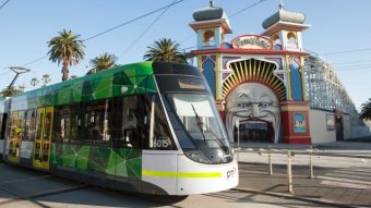 A tram moves past the entrance to Luna Park in St Kilda, Melbourne.