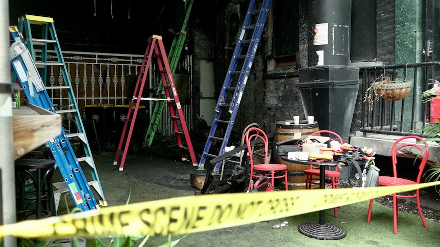 Crime scene tape, ladders, chairs and some burnt area