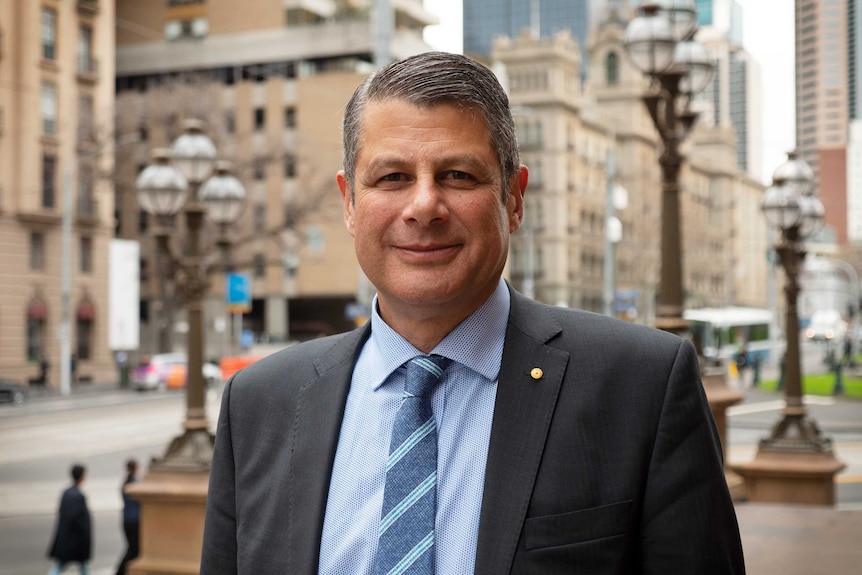 Steve Bracks smiles, with the Melbourne CBD in the background.