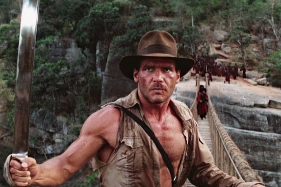 Harrison Ford in at hat on a bridge in a scene from the Temple of Doom