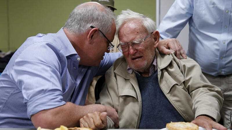 Scott Morrison consoling a crying man.