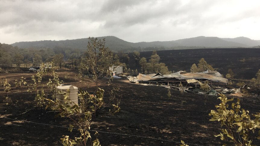 A property flattened by fire and surrounded by scorched land.