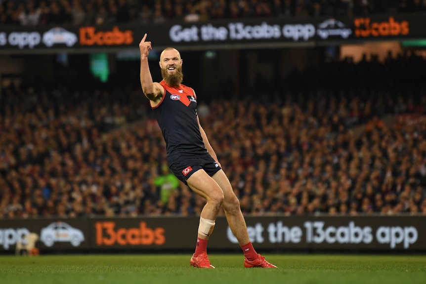 Max Gawn sticks his finger in the air as he celebrates kicking a Demons goal.