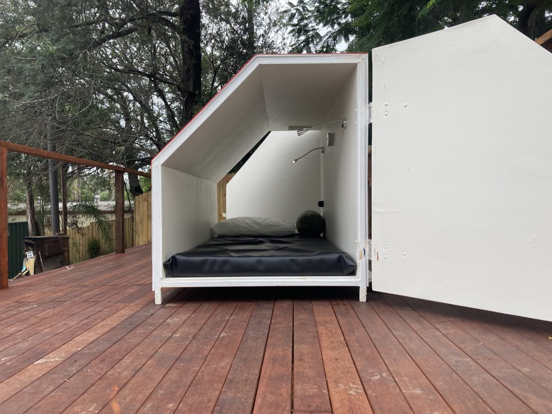 An accommodation pod that contains a mattress and phone charger.
