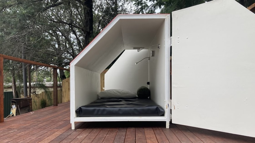 An accommodation pod that contains a mattress and phone charger.
