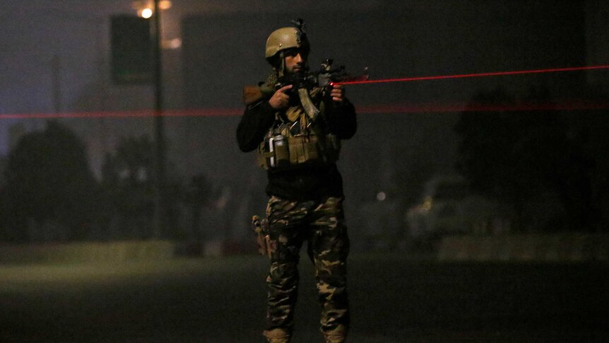 An Afghan security force keeps watch near the site of the attack.