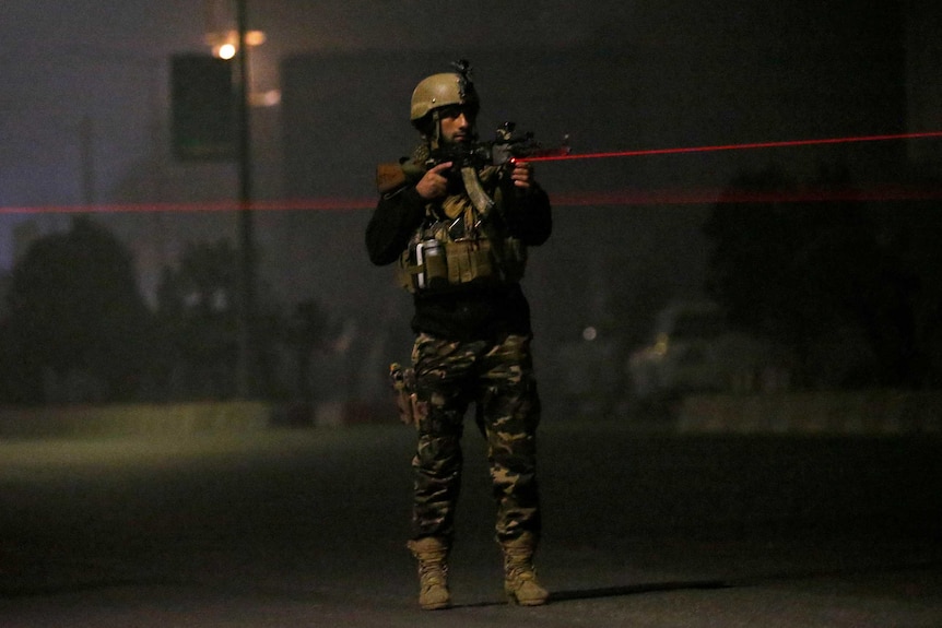 An Afghan security force keeps watch near the site of the attack.