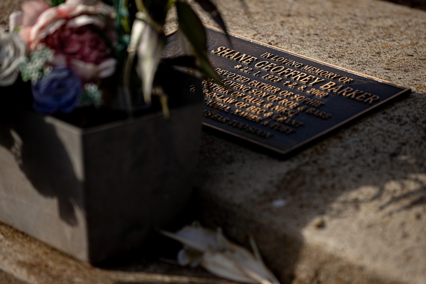 A metal headstone set in concrete of a man, Shane Barker, who died in 2009.