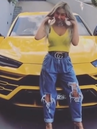 Nissy Nassif poses in front of her yellow Lamborghini