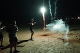 People letting off fireworks on a beach