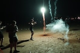 People letting off fireworks on a beach