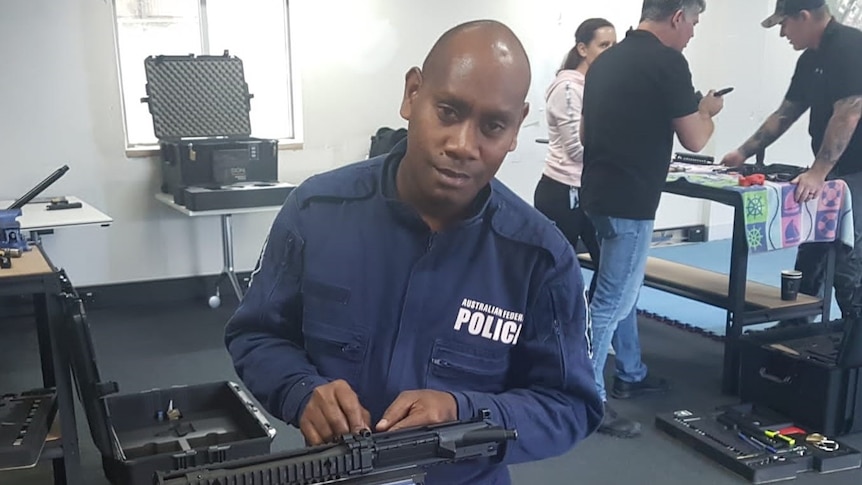 A RSIPF officer works on a gun. 