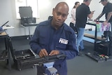 A RSIPF officer works on a gun. 