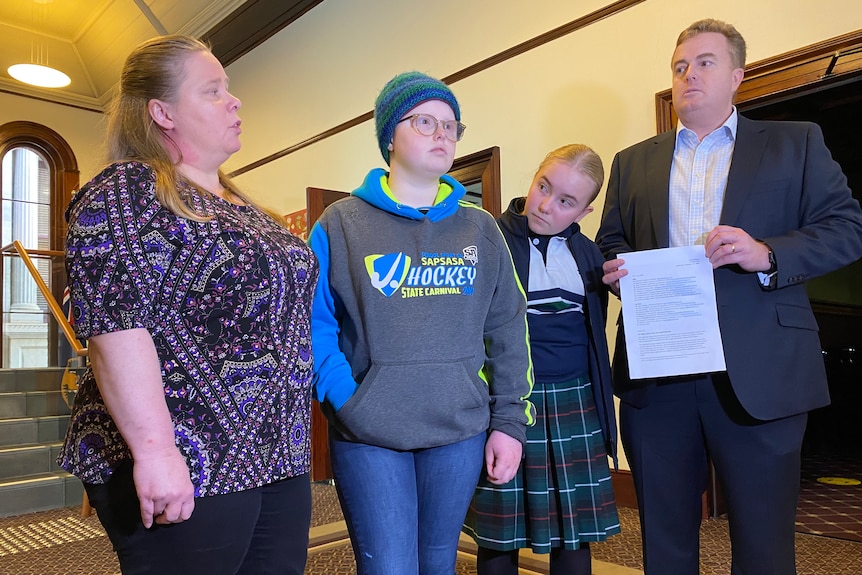 Four family members stand inside a building.