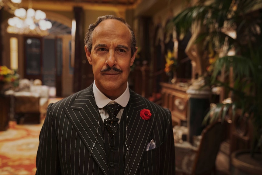 Stanley Tucci in a suit in an old hotel in the movie The Witches