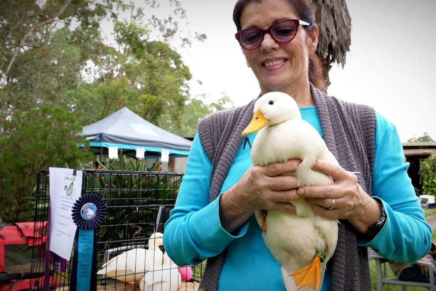 A woman holds a small white duck