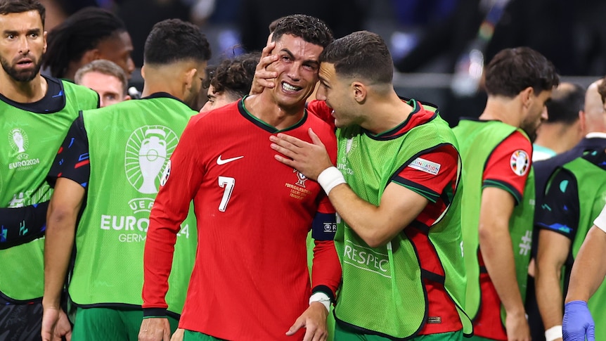 Cristiano Ronaldo is consoled by Diogo Dalot