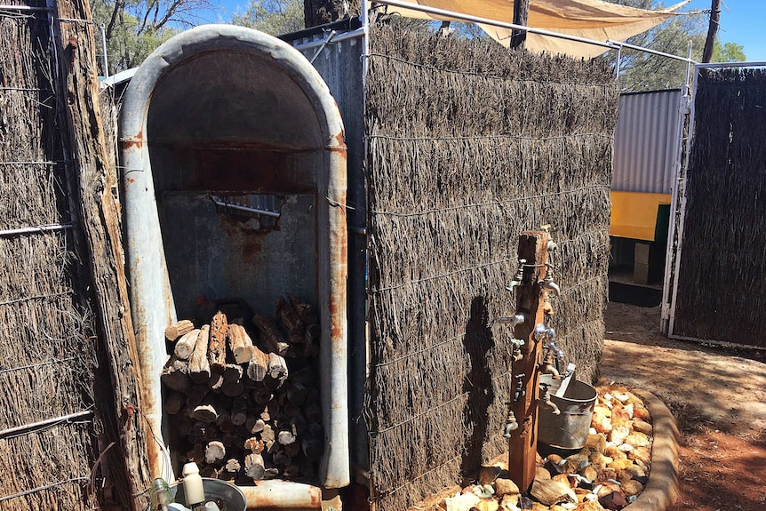 An old iron bath is used as storage for firewood