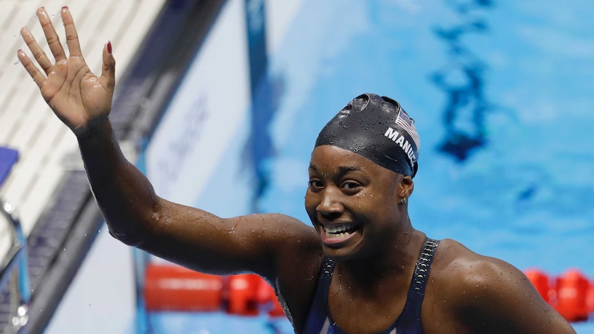 United States' Simone Manuel waves in the pool after winning gold.