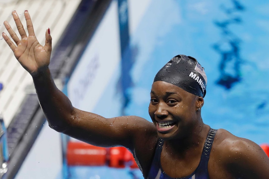 United States' Simone Manuel waves in the pool after winning gold.