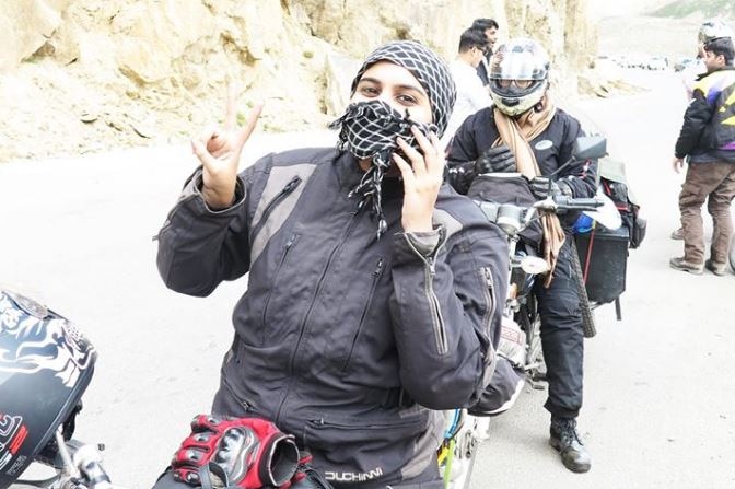 Zenith creates peace sign with her fingers as she poses on her motorbike