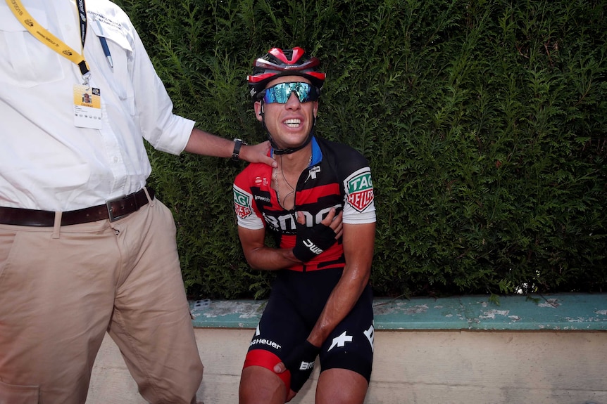 Richie Porte holding his chest in a distressed state after crashing early in the tour de France.
