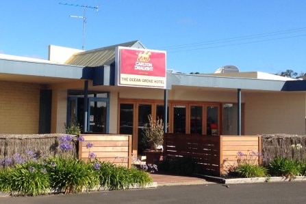 A brick building with a Carlton Draught sign on the front that reads The Ocean Grove Hotel.