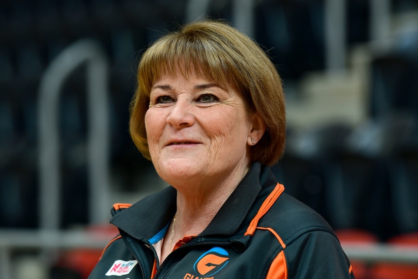 A woman wearing a polo shirt smiles